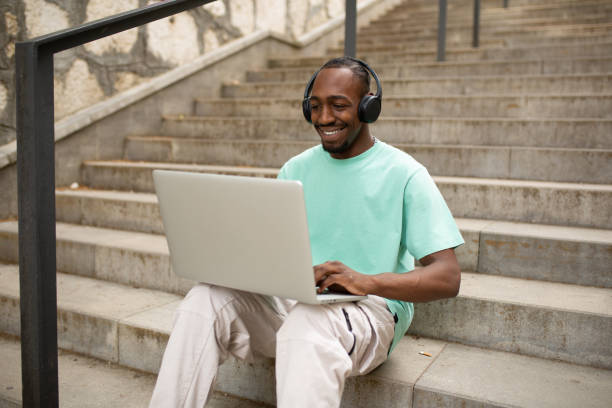 istock Happy young man using a laptop outdoors 1401368895