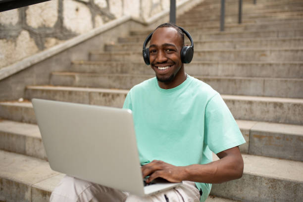 istock Happy young man using a laptop outdoors 1401368916