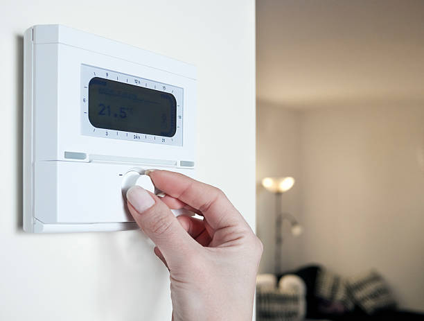 istock Close up of woman's hand adjusting the thermostat 140136992