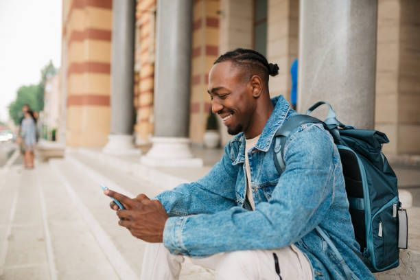 istock Happy young university student using a smart phone outdoors 1401369966