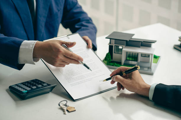 un agente de vivienda o gerente de ventas ofrece una venta y explica los términos de la firma de un contrato de compra de vivienda y un seguro gratuito. concepto hipotecario y servicio postventa inmobiliario - real estate mortgage document key contract fotografías e imágenes de stock