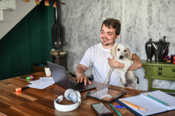 istock Smiling Dwarf Male Keeping Dog Assistant Close By While Working From Home 1401371508