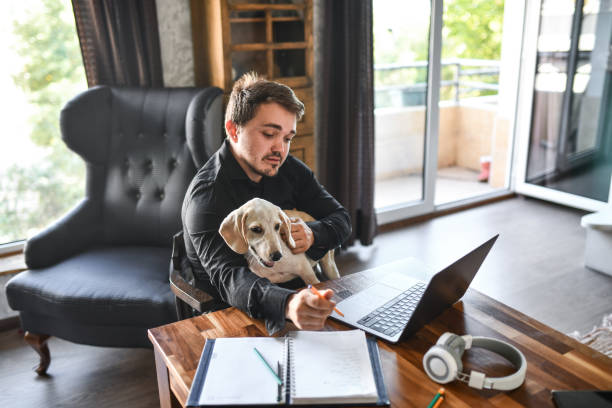 istock Businessman Focused On Completing Daily Tasks From Home While Sitting With Dog 1401372649