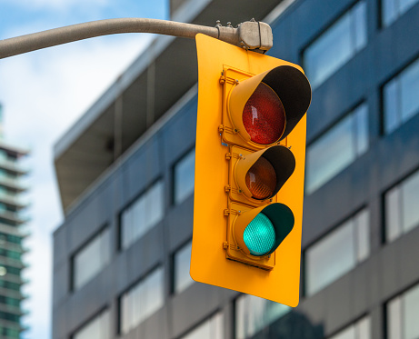 a city crossing with a semaphore, red light in semaphore, traffic control and regulation concept