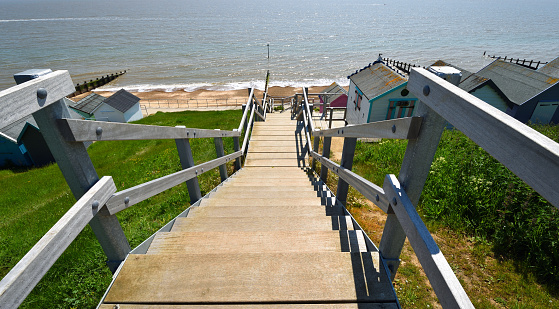 Wooden steps leading down to the sea , steps , beach huts, beach and ocean.