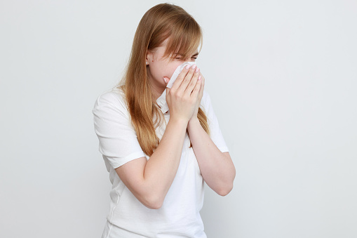 a woman with a napkin is sick on a white background