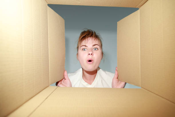 istock a surprised woman looks into the box. delivery 1401374808