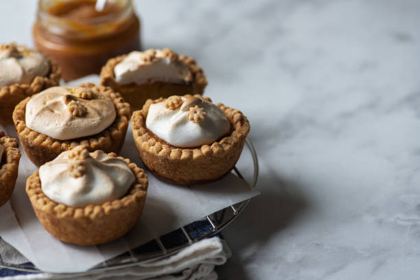 istock Lemon curd tartlets with whipped meringue on a wire rack. Copy space and close up. 1401375870