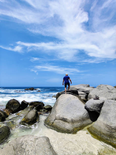 istock Man on boulders in ocean 1401376206