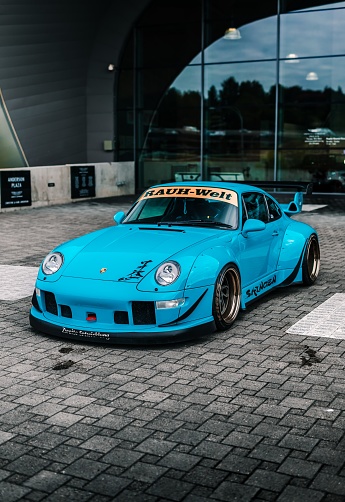 Seattle, WA, USA\n6/2/2022\nBlue RWB Porsche parked in front of a glass wall