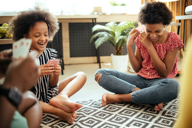 We play cards on the weekends Family is sitting on the living room floor playing cards family playing card game stock pictures, royalty-free photos & images