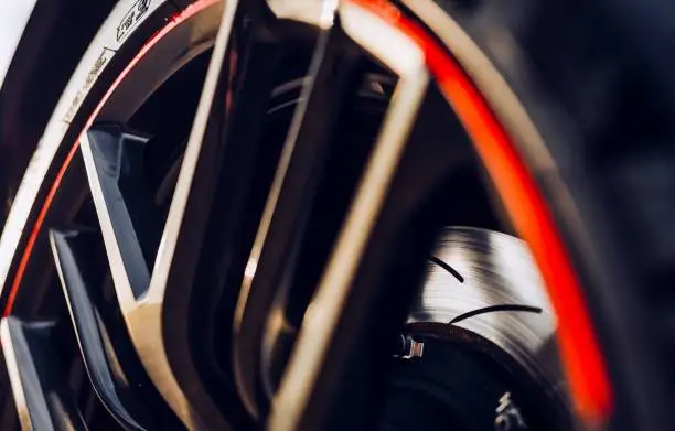 Slotted brake rotor behind a wheel with a red line around the rim