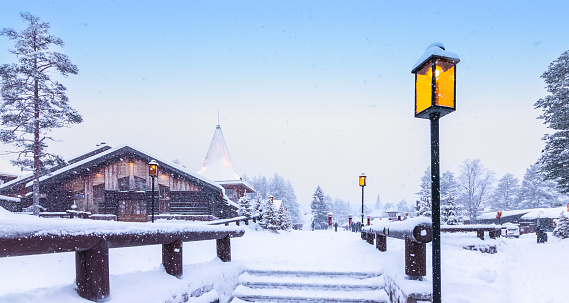 Santa Claus village on a snowy winter day. Illuminated lantern at the stairs of the magical Christmas village. Rovaniemi, Lapland, Finland, Scandinavia.