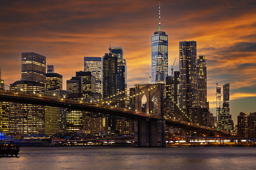 Brooklyn Bridge, World Trade Center and Skyscrapers of the Lower Manhattan Financial District All illuminated at Night, Water of East River and Vivid Orange Yellow Blue Sunset Sky are in the image. Canon EOS 6D (full frame sensor) DSLR and Canon EF 24-105mm F/4L IS lens.