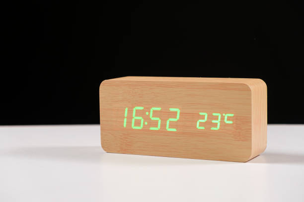 istock Electronic wooden clock with thermometer on black and white background close-up with space for text 1401380712