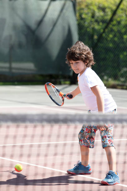 istock Happy boy playing tennis outdoors with a friend. 1401384168
