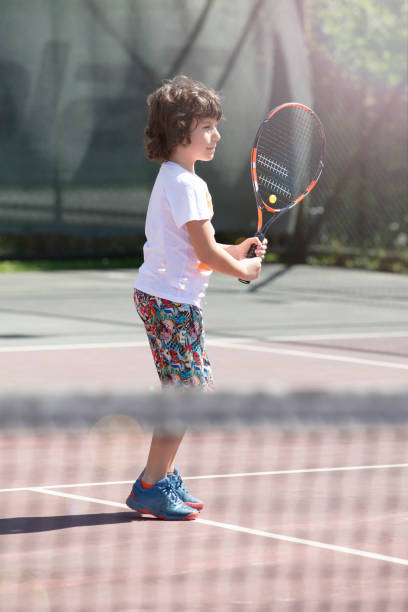 istock Happy boy playing tennis outdoors with a friend. 1401384426