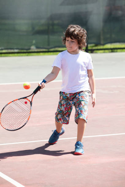 istock Happy boy playing tennis outdoors with a friend. 1401385127