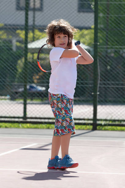 istock Happy boy playing tennis outdoors with a friend. 1401385188