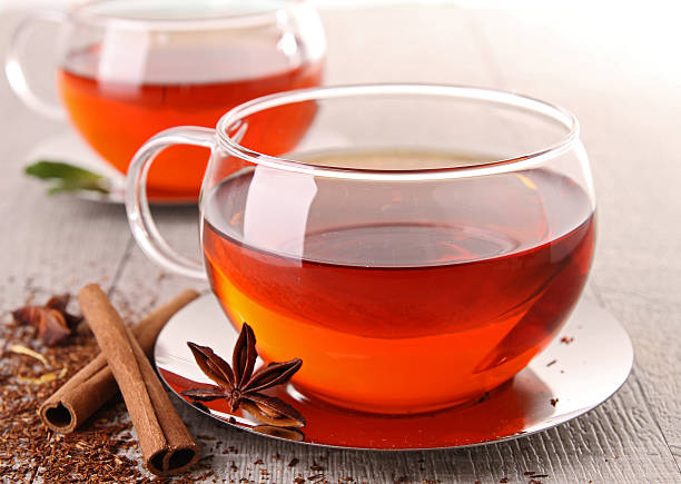 Photo of a transparent tea cup featuring tea extracts around