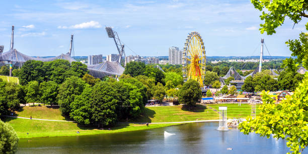 Olympic Park in summer, Munich, Germany, Europe. This place is landmark of Munich. Panorama of green Olympiapark, urban landscape. Scenic view of Munich amusement district, skyline of Munchen city.