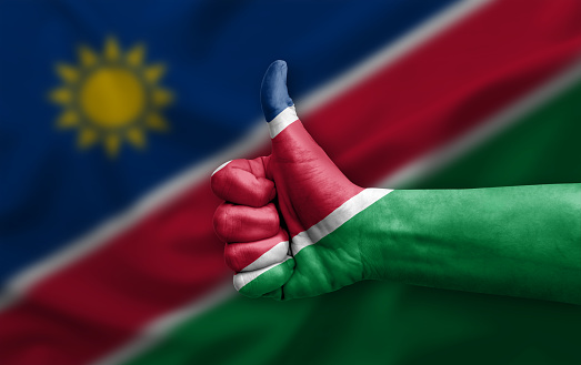 Hand making thumb up painted with flag of namibia