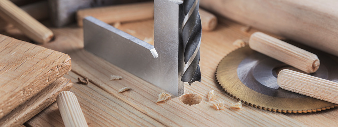 drill bit with steel triangle ruler make sink in hole for screw in wooden oak plank