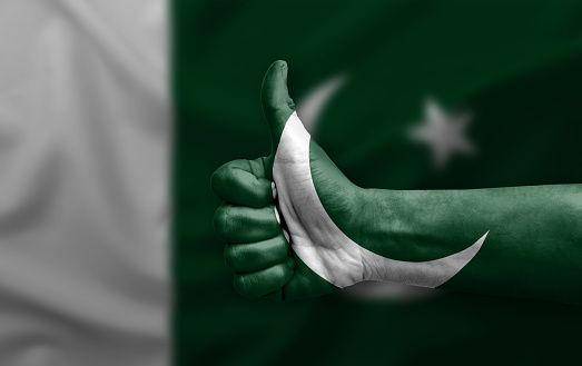 Hand making thumb up painted with flag of pakistan