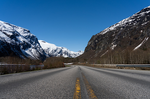 Infinite straight Norwegian road between the mountains