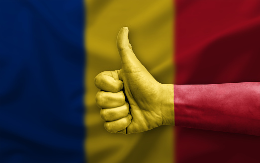 Hand making thumb up painted with flag of romania
