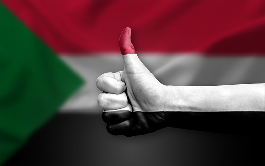 Hand making thumb up painted with flag of sudan