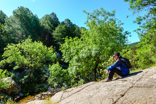 Man sitting on a large rock in the mountain hiking, Guadarrama Madrid