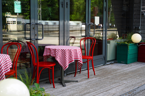 Outdoor cafe red chairs and table with red and white tablecloth