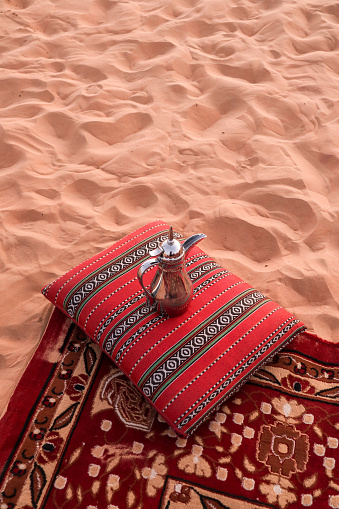Desert dinner set up for sunset romantic meal at sand dunes with carpets and cushions