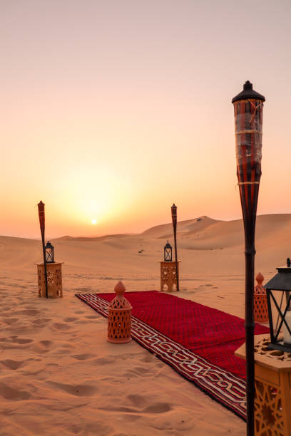 Desert dinner set up for sunset romantic meal at sand dunes with carpets and cushions