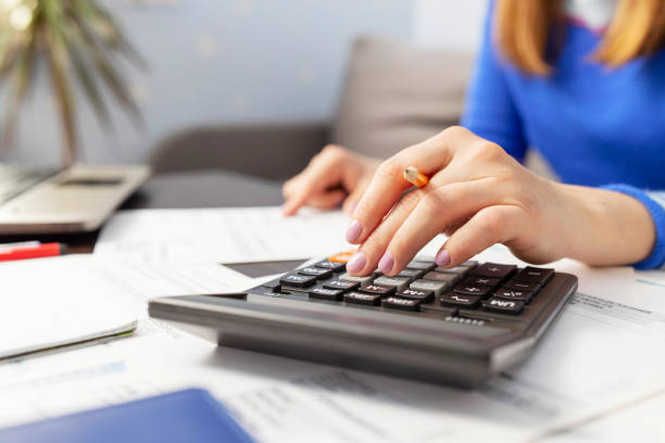 istock Woman using calculator for calculate domestic bills at home, doing paperwork for paying taxes 1401402425