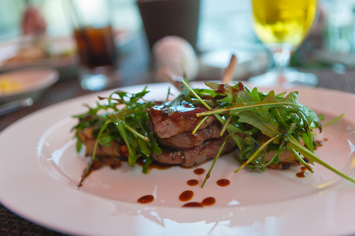 Grilled steak with arugula for lunch in sidewalk restaurant