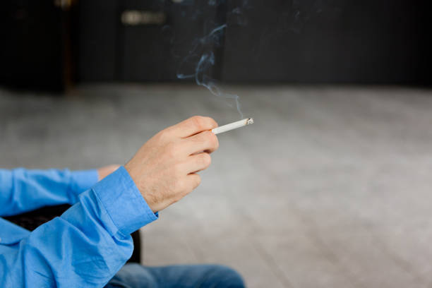 Man holding cigarette stock photo