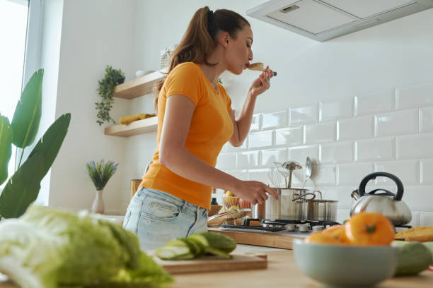 istock Confident young woman tasting something from pan 1401406104