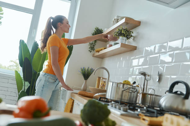 istock Confident young woman putting plates on shelf 1401406122