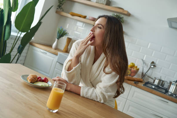 istock Attractive young woman in bathrobe yawning 1401406163
