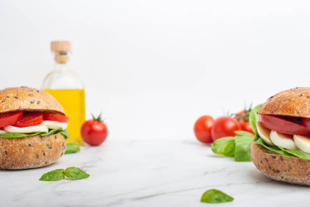 sfondo bianco con panini con tzazzarella e pomodori - mozzarella tomato sandwich picnic foto e immagini stock