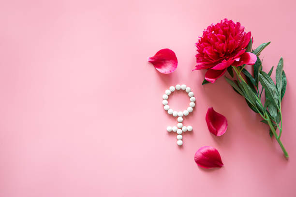 símbolo de venus de género hecho de píldoras y flor de peonía sobre un fondo rosa. - menopausia fotos fotografías e imágenes de stock