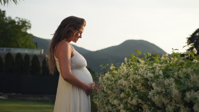 Pregnant woman in a beautiful white peignoir and lingerie Stock