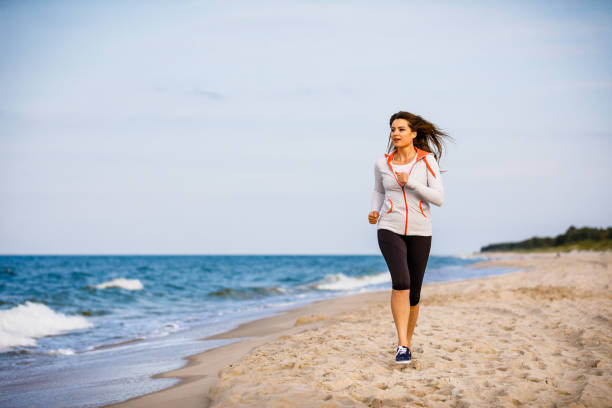 istock Young woman running on beach 1401412799