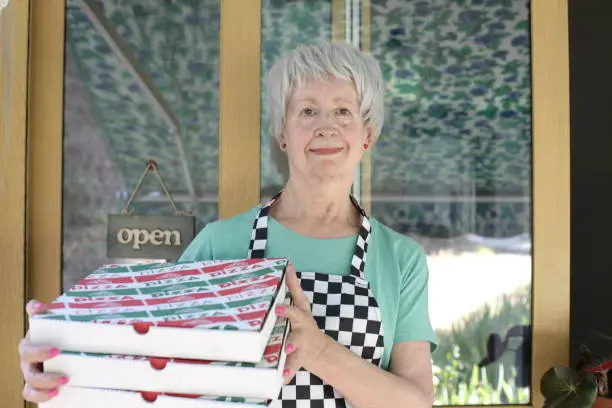 Photo of Female worker holding pizza boxes