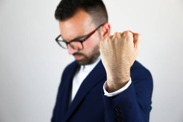 Businessman hitting table with clenched fist.