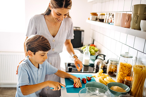 Mother and son preparing healthy salad at home