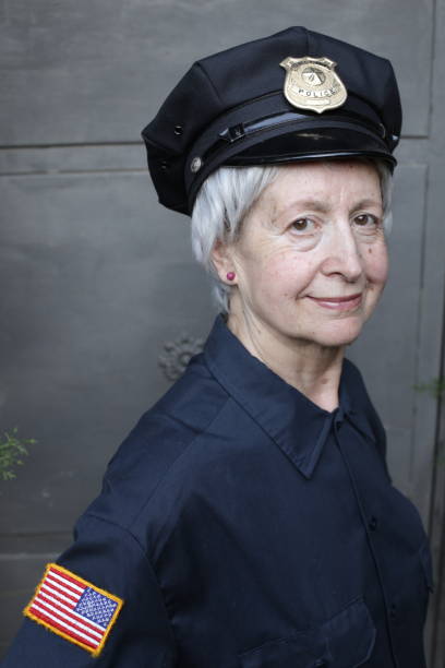 Senior female officer in uniform A senior female police office in uniform is looking at camera.She has gray hair with short length. police policewoman women spain stock pictures, royalty-free photos & images