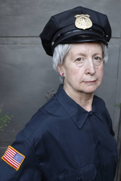 Senior female officer in uniform A senior female police office in uniform is looking at camera.She has gray hair with short length. police policewoman women spain stock pictures, royalty-free photos & images